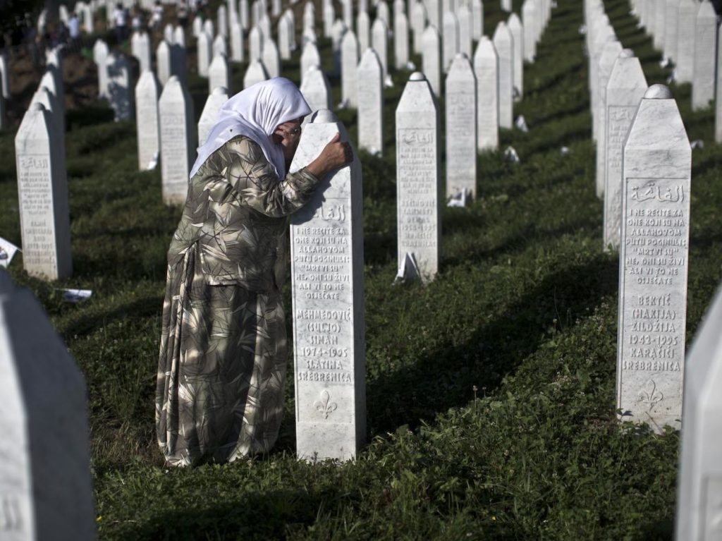 A woman weeps as she visits the grave of a family member at the Potocari memorial complex near Srebrenica, 150 kilometers (94 miles) northeast of Sarajevo, Bosnia and Herzegovina, Saturday, July 11, 2015. Twenty years ago, on July 11, 1995, Serb troops overran the eastern Bosnian Muslim enclave of Srebrenica and executed some 8,000 Muslim men and boys, which International courts have labeled as an act of genocide, and newly identified victims of the genocide are still being re-interred at Srebrenica. (AP Photo/Marko Drobnjakovic)