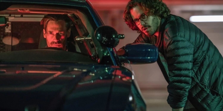 Gözlüklü adam, arabanın içinde oturan adama direktifler veriyor.