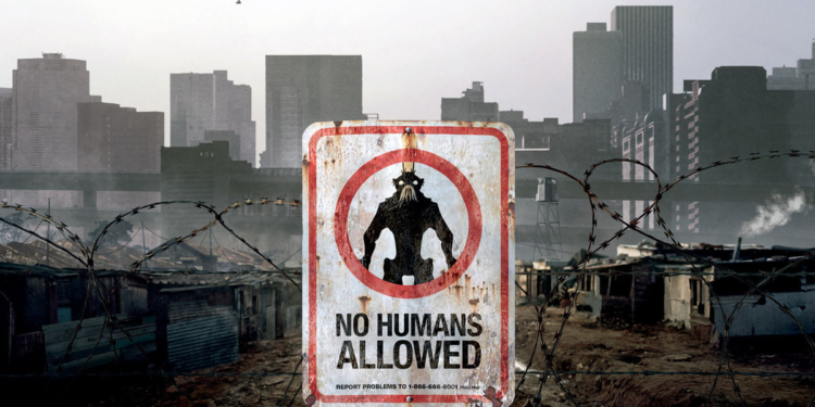 Mülteci kampının girişinde bir tabela var. Tabelaın üstünde bir uzaylı görseli var ve "İnsanlar giremez" yazıyor.